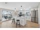 Modern white kitchen featuring stainless-steel appliances and a center island with seating at 13810 Malcolm Ave, Hudson, FL 34667