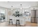 Modern white kitchen features stainless steel appliances and a breakfast bar at 13810 Malcolm Ave, Hudson, FL 34667