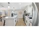 White kitchen with stainless steel appliances, center island, and backyard views at 13810 Malcolm Ave, Hudson, FL 34667