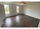 Spacious bedroom with wood flooring, two windows, and closet space at 13909 Fletchers Mill Dr, Tampa, FL 33613