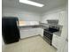 Well-lit kitchen with white cabinetry, modern appliances, and tile flooring at 13909 Fletchers Mill Dr, Tampa, FL 33613