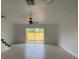 Bright living room with tile floors, ceiling fan and sliding glass doors to the backyard at 13909 Fletchers Mill Dr, Tampa, FL 33613