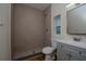 Modern bathroom featuring a walk-in shower with pebble floor, neutral tile, vanity, mirror, and great natural light at 1419 55Th S St, Gulfport, FL 33707