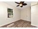 This bedroom features a ceiling fan, wood look floors, and a large window at 1419 55Th S St, Gulfport, FL 33707