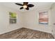 This bedroom features two windows for natural light, ceiling fan, and wood look floors at 1419 55Th S St, Gulfport, FL 33707