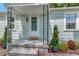 Charming front porch with decorative columns, a 'Hello' mat, and colorful plants at 1419 55Th S St, Gulfport, FL 33707