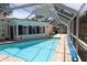Beautiful enclosed pool area with brick trim and clear blue water, perfect for relaxation and recreation at 1525 Albemarle Ct, Dunedin, FL 34698