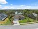 Aerial view featuring a home with a three-car garage and a well manicured lawn near the lake at 15615 Serengeti Blvd, Spring Hill, FL 34610