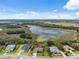Aerial view shows houses near a lake in a residential neighborhood under a partly cloudy, blue sky at 15615 Serengeti Blvd, Spring Hill, FL 34610