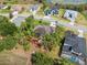 A beautiful aerial view of the backyard featuring a fire pit and pool with lush landscaping and mature trees at 15615 Serengeti Blvd, Spring Hill, FL 34610