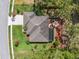 Overhead shot showcasing a home with a backyard fire pit, screened-in patio, and manicured lawn at 15615 Serengeti Blvd, Spring Hill, FL 34610