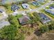Aerial view showing the home, screened in patio, yard and community with pond nearby at 15615 Serengeti Blvd, Spring Hill, FL 34610