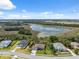 Aerial view of homes in the neighborhood with a lake and greenery under a partly cloudy sky at 15615 Serengeti Blvd, Spring Hill, FL 34610