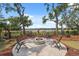 Circular backyard brick patio featuring a fire pit with seating and a view of the lake at 15615 Serengeti Blvd, Spring Hill, FL 34610