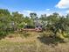 Aerial view of the home's lush backyard with a screened patio, outdoor seating, and a charming fire pit area at 15615 Serengeti Blvd, Spring Hill, FL 34610