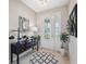 Inviting foyer with a decorative mirror, stylish console table, and elegant front door at 15615 Serengeti Blvd, Spring Hill, FL 34610