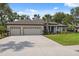 Beautiful home featuring a long driveway, three-car garage, and well-maintained lawn and landscaping at 15615 Serengeti Blvd, Spring Hill, FL 34610