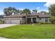 Beautiful home with a well-manicured lawn, three-car garage, and colorful front garden at 15615 Serengeti Blvd, Spring Hill, FL 34610