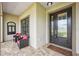 Charming covered porch with seating area, stylish door, and neutral flooring at 15615 Serengeti Blvd, Spring Hill, FL 34610