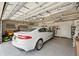 Clean garage boasting epoxy-coated floors, overhead storage racks, and a white Jaguar at 15615 Serengeti Blvd, Spring Hill, FL 34610