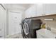 Functional laundry room with white cabinets, a sink, and a modern washer and dryer at 15615 Serengeti Blvd, Spring Hill, FL 34610
