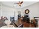 Cozy living room featuring dark wood floors, a ceiling fan, and lots of seating at 15615 Serengeti Blvd, Spring Hill, FL 34610