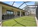 Large screened-in patio with ceiling fans, turf, and brick flooring at 15615 Serengeti Blvd, Spring Hill, FL 34610