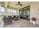 Covered patio featuring ceiling fan, wicker loveseat and chairs, and sliding glass doors at 15615 Serengeti Blvd, Spring Hill, FL 34610