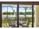 Screened patio with outdoor dining set overlooking lush backyard and serene water view at 15615 Serengeti Blvd, Spring Hill, FL 34610