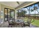 Back screened-in patio featuring ceiling fan, brown brick flooring, and outdoor seating with a lake view at 15615 Serengeti Blvd, Spring Hill, FL 34610