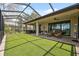 Wide view of large screened-in back patio with brown brick flooring and lake view at 15615 Serengeti Blvd, Spring Hill, FL 34610