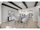 Open-concept dining room with modern chandelier, wooden beams, and light wood floors at 206 S Tampania Ave # 4, Tampa, FL 33609