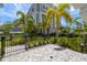 Charming exterior of a three-story home showcasing a paved patio, tropical landscaping, and a decorative fence at 206 S Tampania Ave # 4, Tampa, FL 33609