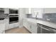 Modern farmhouse kitchen featuring stainless steel appliances, white cabinets, and blue subway tile backsplash at 206 S Tampania Ave # 4, Tampa, FL 33609