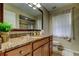 Bathroom with wood cabinets, granite countertop, and a framed mirror at 2547 Stony Brook Ln, Clearwater, FL 33761
