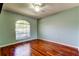 Bedroom features a ceiling fan, hardwood floors, and a large window at 2547 Stony Brook Ln, Clearwater, FL 33761