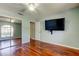 Bedroom features a mirrored closet, hardwood floors, and TV at 2547 Stony Brook Ln, Clearwater, FL 33761