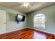 Bedroom features a ceiling fan, hardwood flooring, and a large window at 2547 Stony Brook Ln, Clearwater, FL 33761