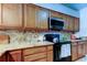A close view of granite countertops, stove and hardwood cabinets at 2547 Stony Brook Ln, Clearwater, FL 33761