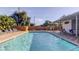Long, narrow outdoor pool with clear blue water and a deck lined with lounge chairs and some greenery at 2547 Stony Brook Ln, Clearwater, FL 33761