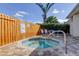 A private outdoor spa featuring a wooden fence, lush foliage, and a cozy seating area at 2547 Stony Brook Ln, Clearwater, FL 33761