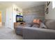 Cozy living room showcases a gray sectional sofa and a rustic wood-paneled accent wall at 3000 Jacob Crossing Ln, Holiday, FL 34691