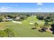 Aerial view showcasing a golf course winding through a community, featuring manicured greens and lakes at 3276 Hilary Cir, Palm Harbor, FL 34684
