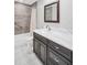 Updated bathroom featuring marble vanity top, dark wood cabinets, tiled shower and bright lighting at 3276 Hilary Cir, Palm Harbor, FL 34684