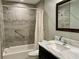 Stylish bathroom featuring tiled walls, a modern vanity with marble countertop, and a shower-tub combination for convenience at 3276 Hilary Cir, Palm Harbor, FL 34684