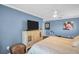 Bright bedroom featuring blue walls, a TV atop a cream dresser, and an exercise machine, offering a comfortable living space at 3276 Hilary Cir, Palm Harbor, FL 34684