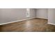 Neutral bedroom featuring a window and wood-look flooring at 3276 Hilary Cir, Palm Harbor, FL 34684