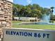 Community entrance with a fountain, landscaping, and community name sign at 3276 Hilary Cir, Palm Harbor, FL 34684