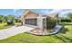 Attractive home featuring a screened garage, flowering bushes, and fresh green lawn at 3276 Hilary Cir, Palm Harbor, FL 34684