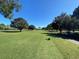 Golf course tee box with well-maintained grass, trees and the fairway in the background, under a blue sky at 3276 Hilary Cir, Palm Harbor, FL 34684